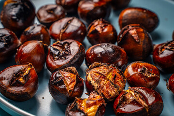 Roasted chestnuts on a blue plate. Close-up. View from above. High quality photo