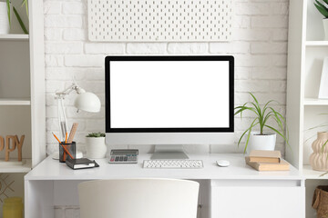 Workplace with computer monitor and plant in office