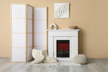 Fireplace, pillows and folding screen in interior of light living room