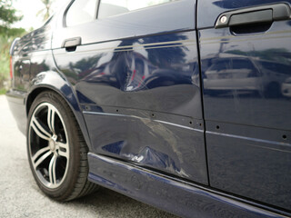Fototapeta premium Vehicle Damage Assessment: This image shows a car with a noticeable dent and scratches on the door, indicating the need for repair or assessment.