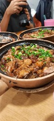 Claypot rice dish for three, packed with tender chicken, savory sausage, and a smoky, crispy rice crust.