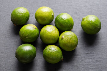 Fresh Green Limes On A Black Slate Background