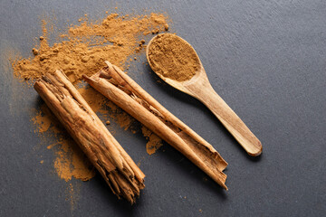 Cinnamon Sticks and Powder on Gray Slate