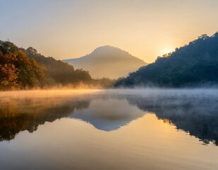 Fototapeta premium Peaceful Lake at Sunrise, With Mist Rising From the Water and a Lone Mountain Reflecting on the Calm Surface, Surrounded by Autumn Forests in Soft Morning Light