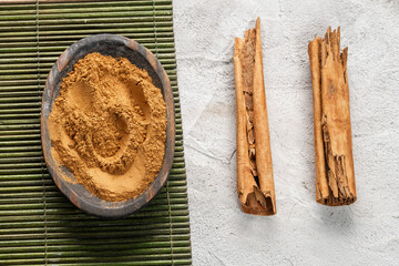 Cinnamon Sticks and Powder on Wooden Surface