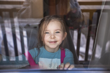 Mom photographs her daughter through the window. Reflections Life style. Positive emotions.