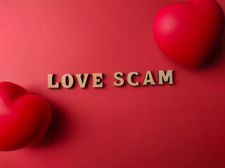 Top view red heart shaped with text LOVE SCAM on a red background