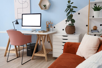 Interior of stylish living room with workplace, drawers and sofa