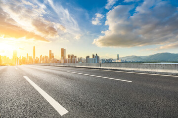 Asphalt highway road with modern city buildings scenery at sunrise in Shenzhen. car advertising background.