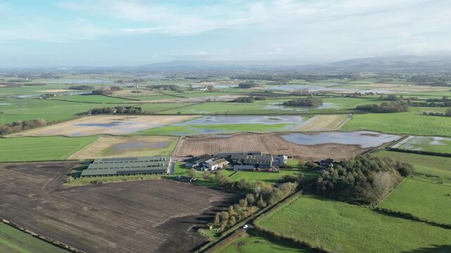 Aerial shot of waterlogged farmland at Eagland Hill, Lancashire. The slow-moving drone footage captures flooded fields and peaceful rural setting under a autumn blue sky.