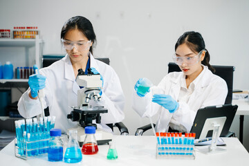 Asian Female Scientists Conducting Chemistry Research in Laboratory