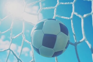 Soccer ball in the net, with bright sun shining through the goal net.