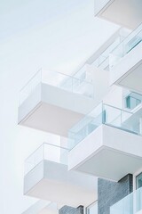 Obraz premium Modern White Building with Overlapping Balconies and Glass Railings