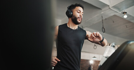 Man, exercise and check watch on treadmill at gym for running speed, monitor performance and cardio...