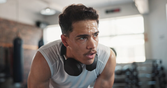 Gym, man and tired with breathing for fitness, cardio training and exhausted for health workout. Rest, male person and bodybuilder with thinking for exercise sweat, wellness recovery and headphones - Powered by Adobe