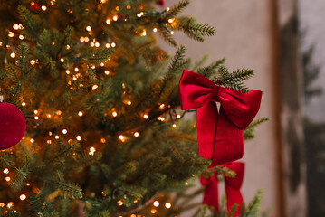 Red bow is hanging from a Christmas tree