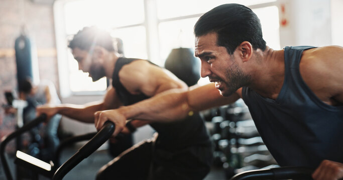 Competitive, exercise bike and sweating with men in gym for fitness, training or intense workout. Effort, elliptical machine and sweat with friends in fitness class for cardio or physical challenge