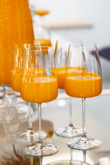 Freshly served orange juice in a stylish dispenser at a modern brunch event on a bright sunny afternoon
