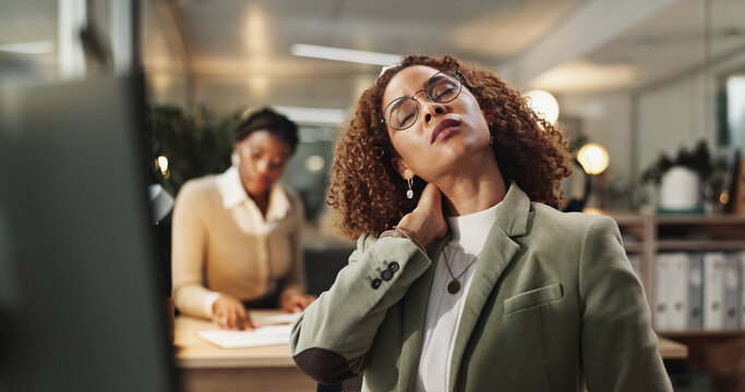 Woman, neck pain and injury at night in office with stress, frustrated or ache at startup company. Person, strain and laptop with muscle fatigue, burnout or tired with bad posture at creative agency