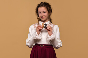 Young girl displaying black and white chess knights