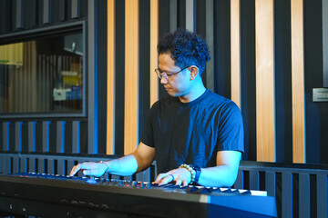 Musician playing music keyboard, Asian man playing piano and practicing in home studio