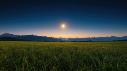 Fototapeta premium A serene landscape at dusk with rolling hills and a glowing sun.