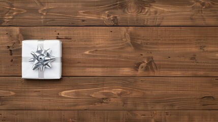 White gift box with a silver bow on a rustic wooden background.