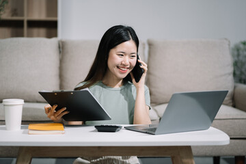 Smiling woman in headphones taking notes, motivated interested student studying online, using tablet, watching webinar training or listening to lecture, remote education concept.