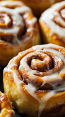 Close-up of freshly baked cinnamon rolls with icing, showcasing their gooey texture and golden brown color. Perfect for dessert, bakery, and comfort food themes.