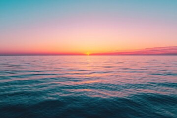 Obraz premium A colorful sunset over a calm ocean with the horizon in the distance.