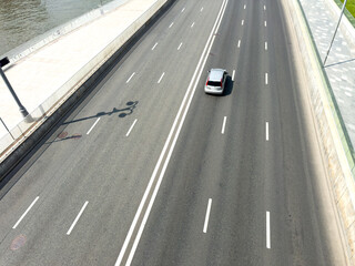 A car is driving down a highway with a white line separating the lanes