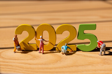 Miniature figurines painting large, colorful 2025 numbers, Perfect for New Year's promotions