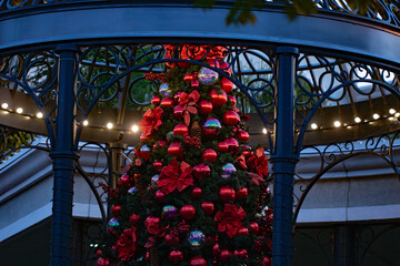 large Christmas tree with red shiny ball ornaments in a park in downtown Newport Beach, California...