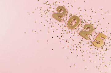2025 Happy New Year. Top view of gold numbers, gold stars confetti on pink background. Copy space,...