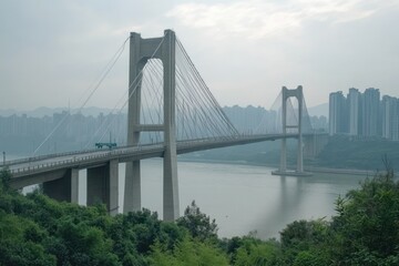 Obraz premium A cable-stayed bridge spans a river with a city skyline in the background.