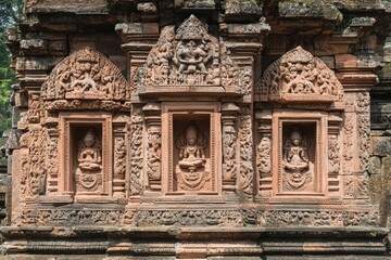 Intricate stone carvings of deities on a temple facade, showcasing cultural artistry.