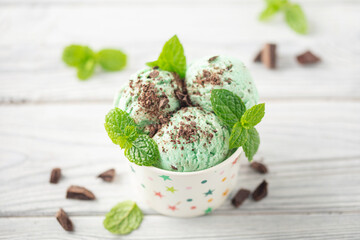 Mint chocolate ice cream balls  in paper bowl on white background