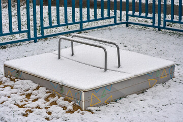 the children's sandbox is covered in winter