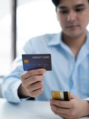 Online shopping action credit card payment by a young man in a modern office environment focused on e-commerce concepts