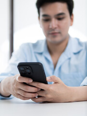 Mobile technology usage by a young man in a modern office environment focused on communication and connectivity