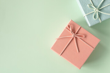 Top view, flat lay with copy space of pink gift box over green background. Gift box for concept for happy birthday, thank you, congratulation, mother's day, anniversary, Valentine's day.