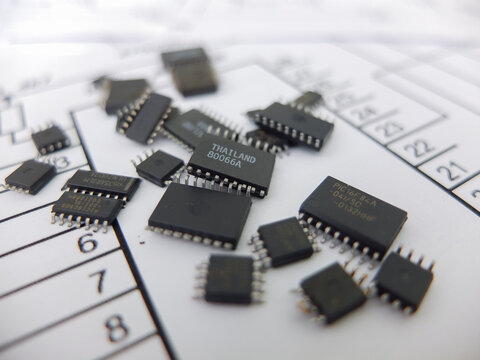 Various integrated circuits, microcontrollers in DIP SOIC TQFP packages. On the back there is a schematic diagram