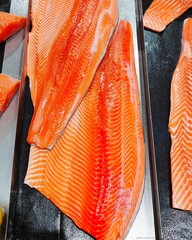 Fresh salmon fillets are sold in supermarkets.