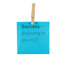 blue success is believing in yourself motivational sticky note with clothespin isolated on white background