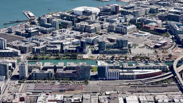 Aerial view of the Caltrain station in San Franciscos Mission Bay area, featuring parked trains, adjacent residential buildings, and the nearby canal.