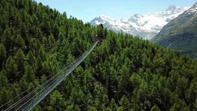 Drone shot at the Charles Kuonen Suspension Bridge (H&auml;ngebr&uuml;cke), with the snowy mountains at the horizon in Randa, Wallis, Switzerland