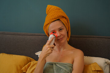 Young woman using infrared massager 