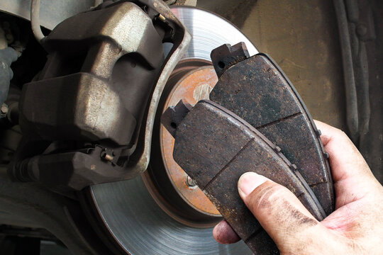 Auto mechanics replace worn brake pads to maintain a car braking system , Car maintenance concept