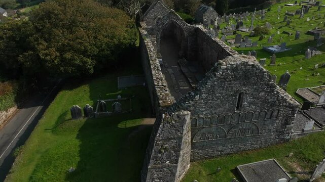 St. Declan's Monastery, Ardmore, County Waterford, Ireland, September 2024. Drone counter clockwise close up orbit over ruins of the Cathedral surrounded by the 12th century cemetery on a sunny day.