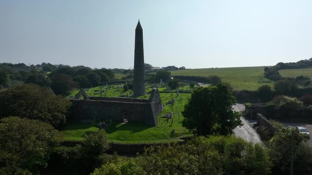 St. Declan's Monastery, Ardmore, County Waterford, Ireland, September 2024. Drone orbits counter clockwise and ascends from behind the Round Tower as North Atlantic Ocean is revealed in the distance.